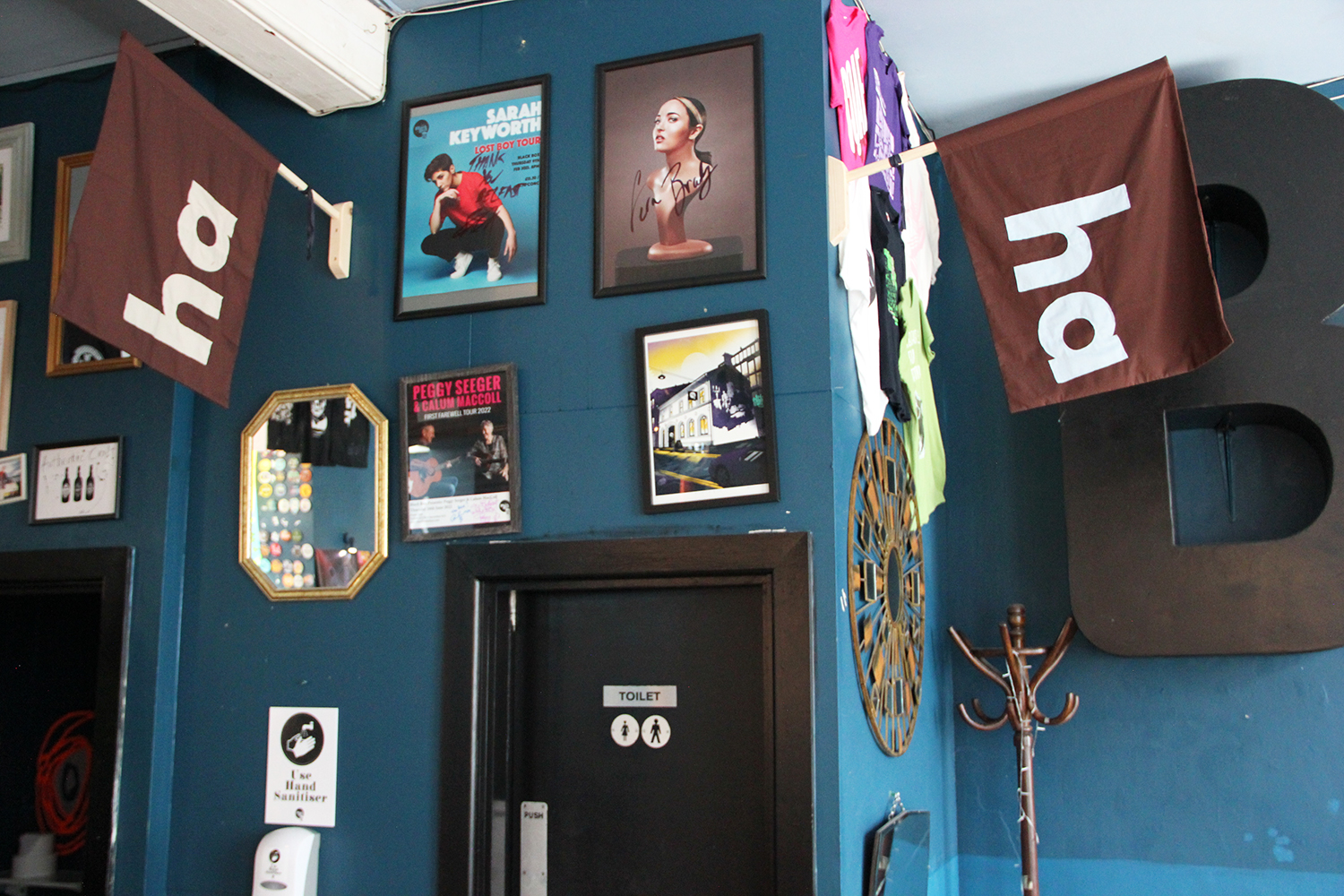 image showing two 'ha ha' flags mounted on the wall in the Green Room bar above the toilet doors.